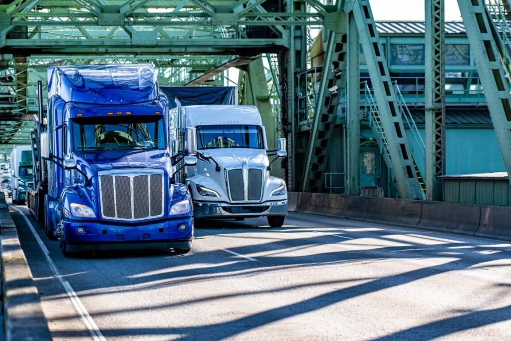 two semi-trucks crossing the bridge 