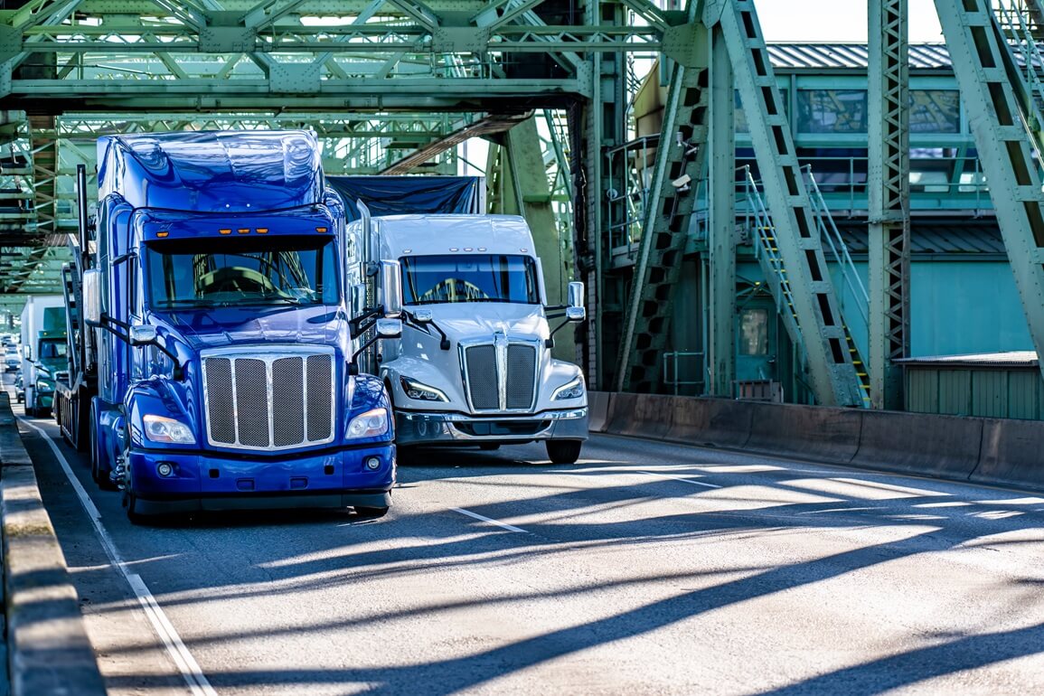 two semi-trucks crossing the bridge