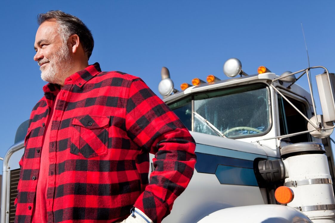 a cargo trucker in front of his rig