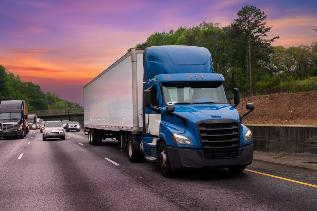 a truck on a highway in atlanta sun setting behind