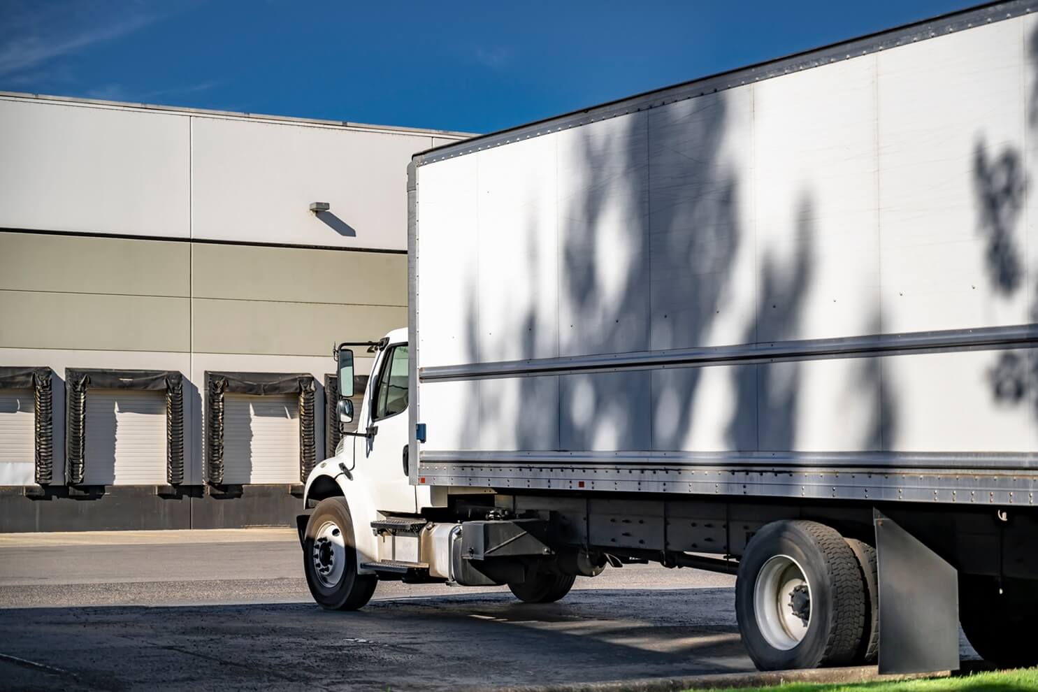 a white rig standing near the warehouse