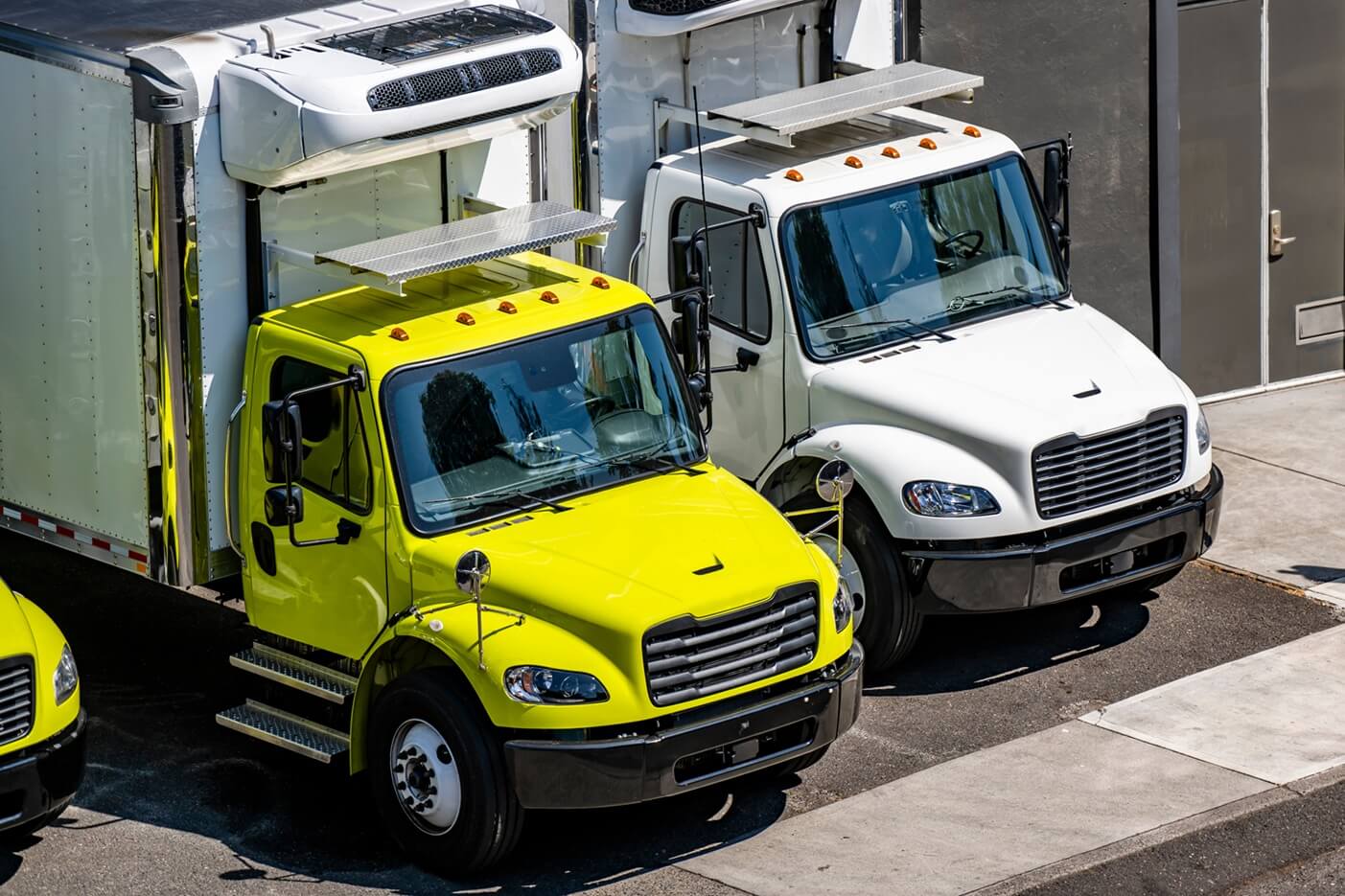 two parked semi-trucks with refrigerated box trailers