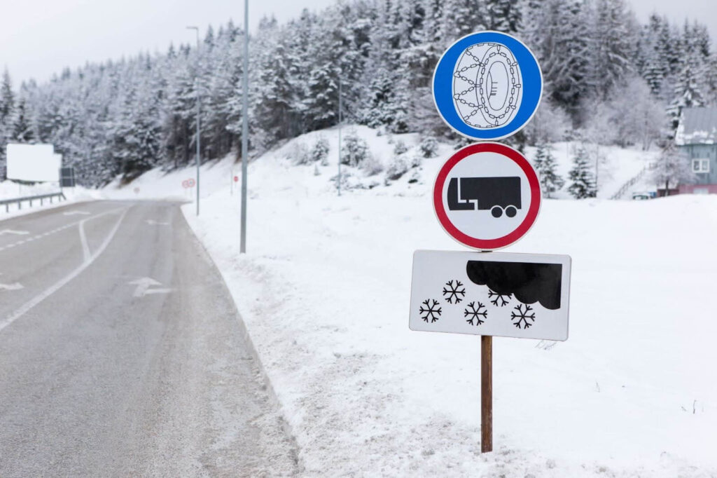 a road sign warning about the need to use snow chains