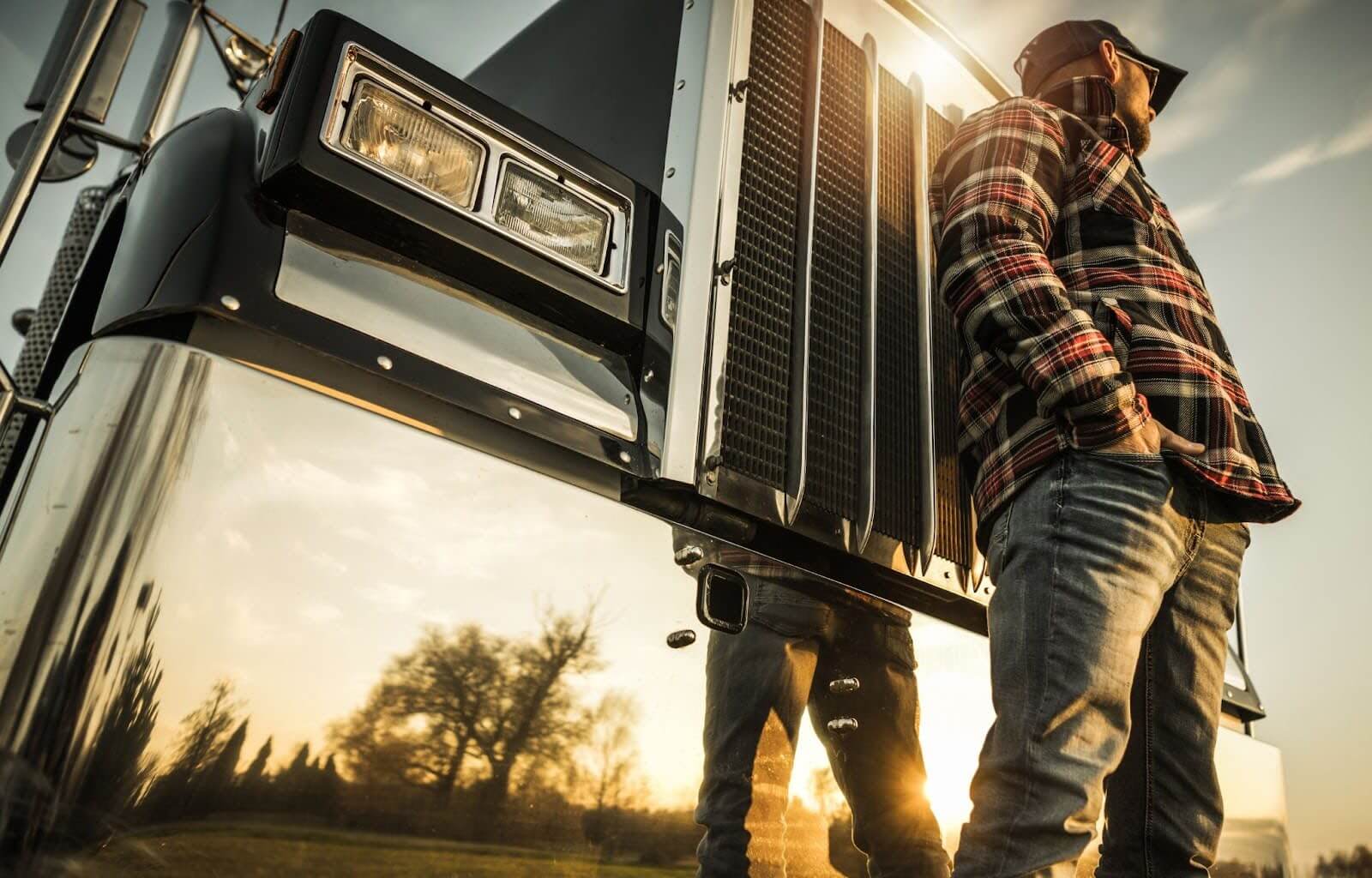 semi truck driver standing in front of his vehicle