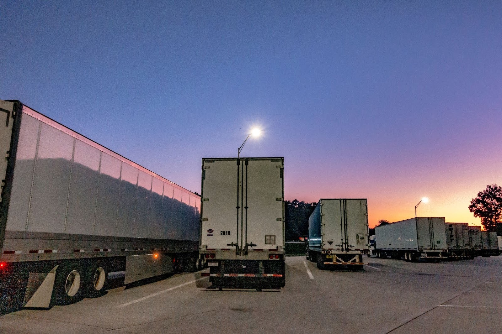 big rig semi trucks and trailers at a truck parking lot